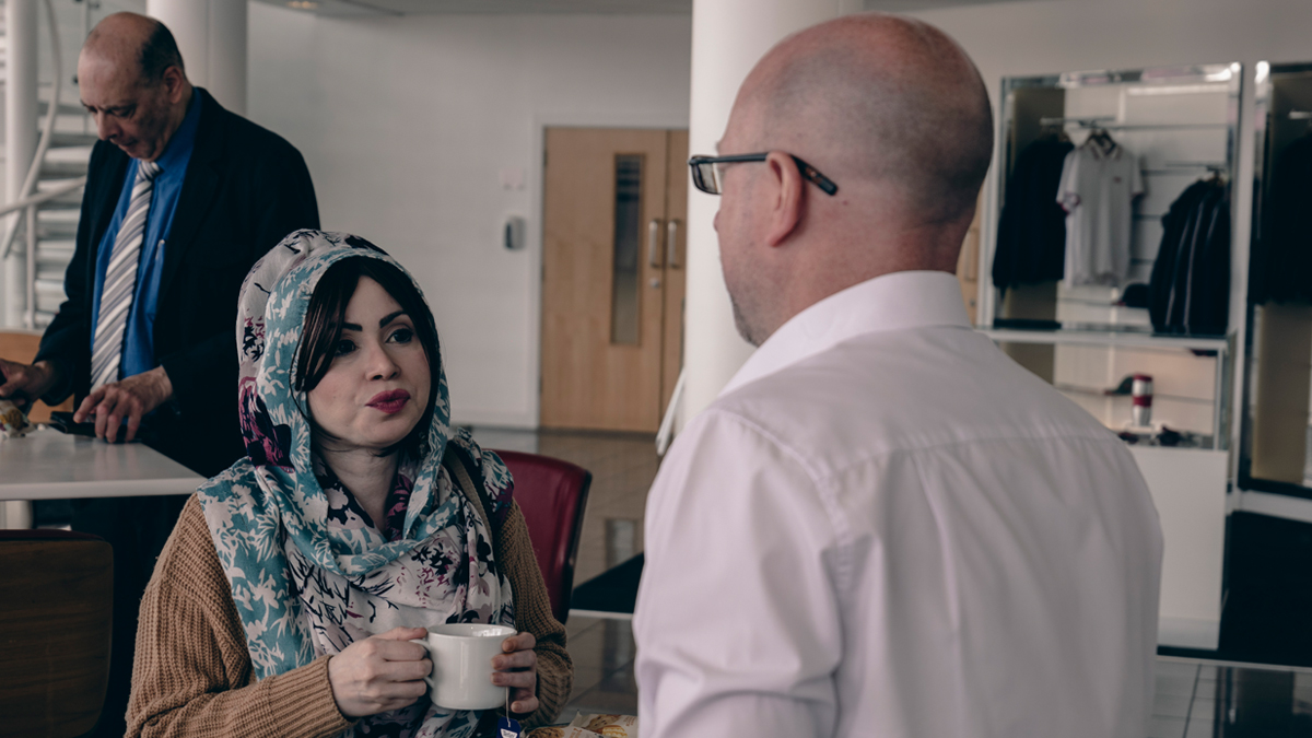 Two professionals talking over coffee in an industry venue